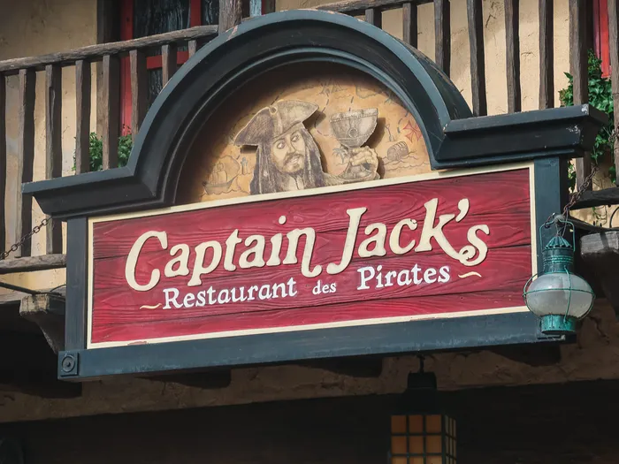 Enseigne rouge sculptée de Captain Jack’s Restaurant des Pirates, avec figure de pirate, à Adventureland.