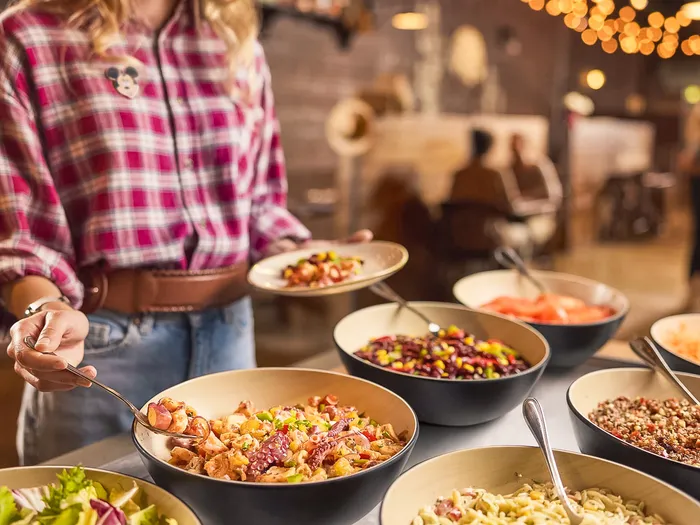 Personne se servant au buffet du Billy Bob’s Buffet, bols de salades et de légumes variés
