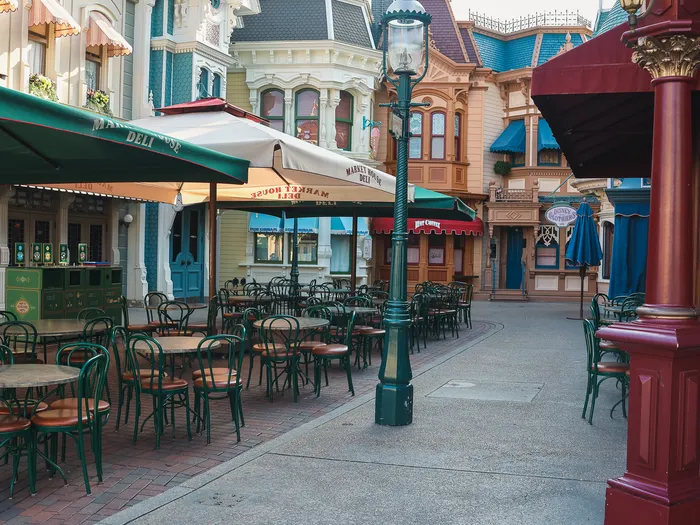 Tables et chaises vides sous parasols en terrasse du Market House Deli le long de Main Street
