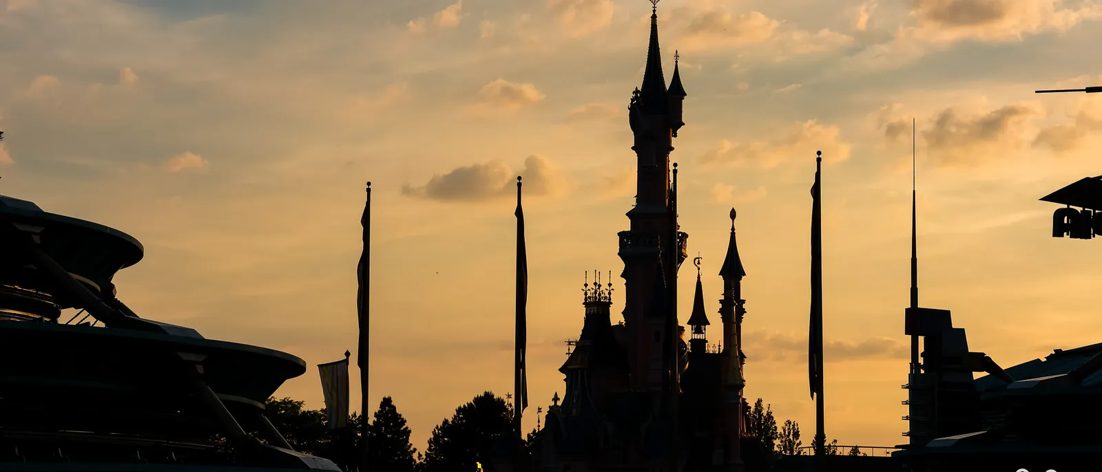 silhouette du château de la Belle au Bois Dormant et des mâts au coucher du soleil, Parc Disneyland.