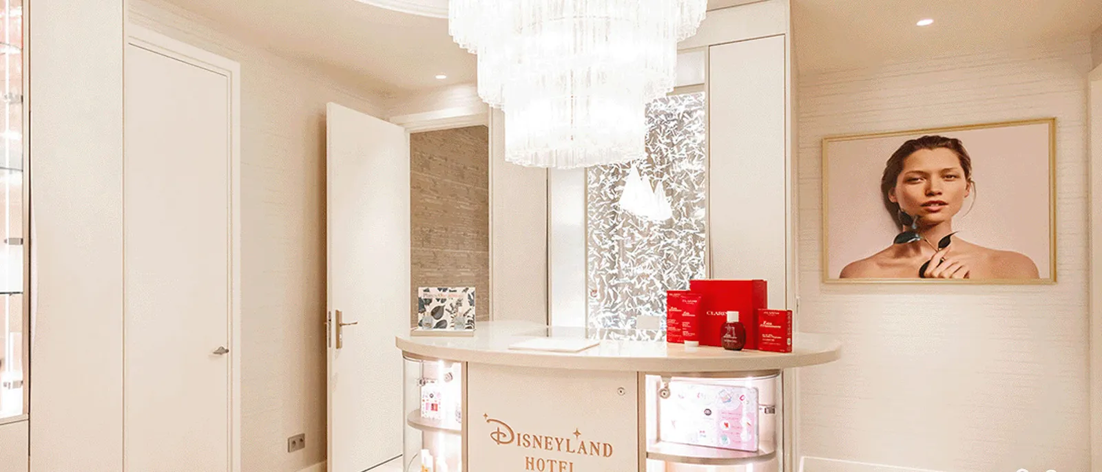 accueil du spa Clarins du Disneyland Hotel, comptoir illuminé, lustre en cristal et produits Clarins.