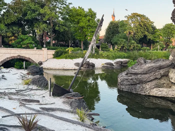 Épave échouée sur la plage d’Adventure Isle, flèche du château au loin, Adventureland