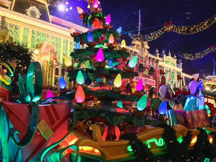 Char en forme de sapin aux grosses ampoules colorées descendant Main Street illuminée pendant la parade de Noël.