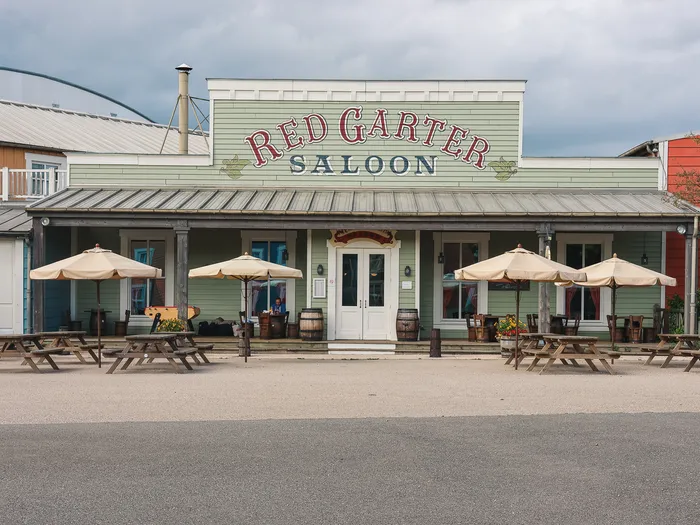 Façade verte du Red Garter Saloon avec tables et parasols en terrasse à l’hôtel Cheyenne.