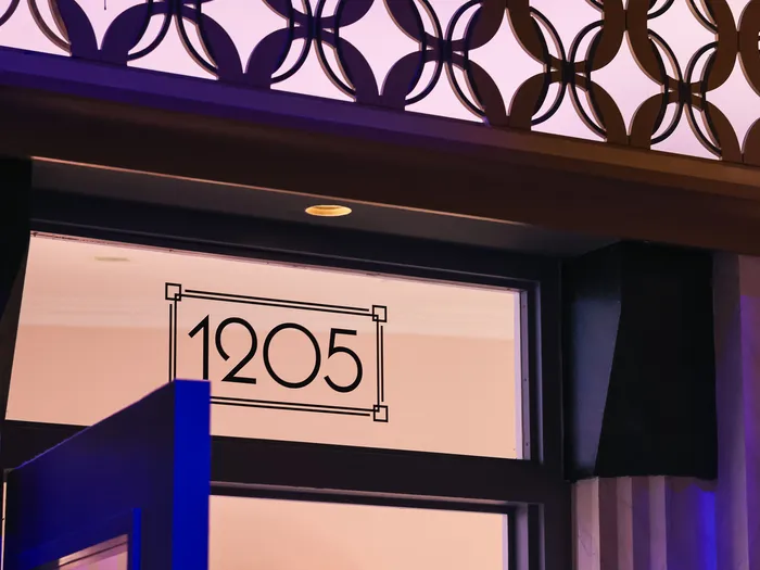 The number 1205 painted in an Art Deco frame on the shop front, below a frieze of interlocking circles lit in blue, at Disneyland Paris.
