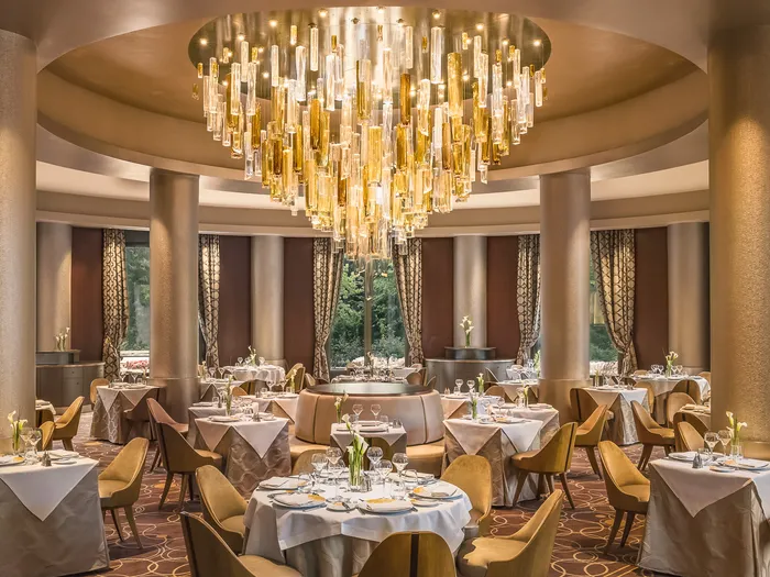Salle élégante du Manhattan Restaurant avec un grand lustre doré en cascade, au Disney Hotel New York