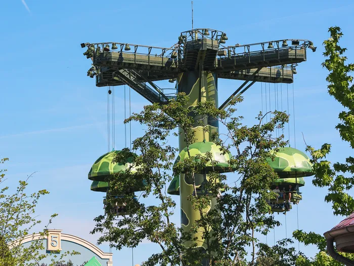 La tour verte et les nacelles-parachutes de Toy Soldiers Parachute Drop dominent la végétation à Worlds of Pixar.