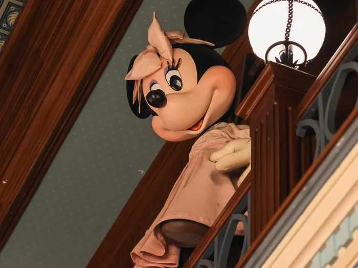 Minnie figure leaning over a wooden balustrade at The Storybook Store
