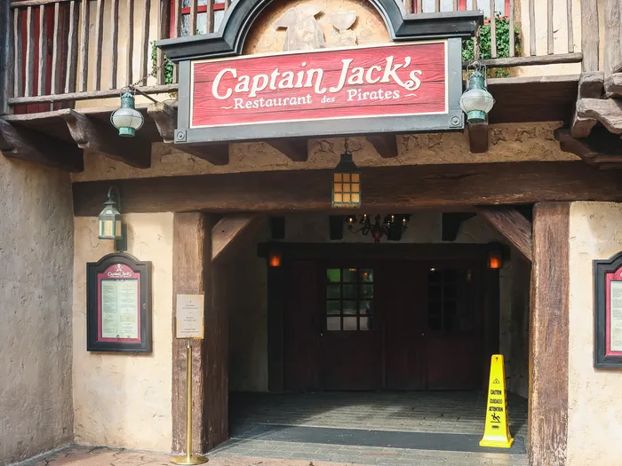 Entrée en bois du restaurant Captain Jack’s à Adventureland, sous son enseigne rouge et ses lanternes.