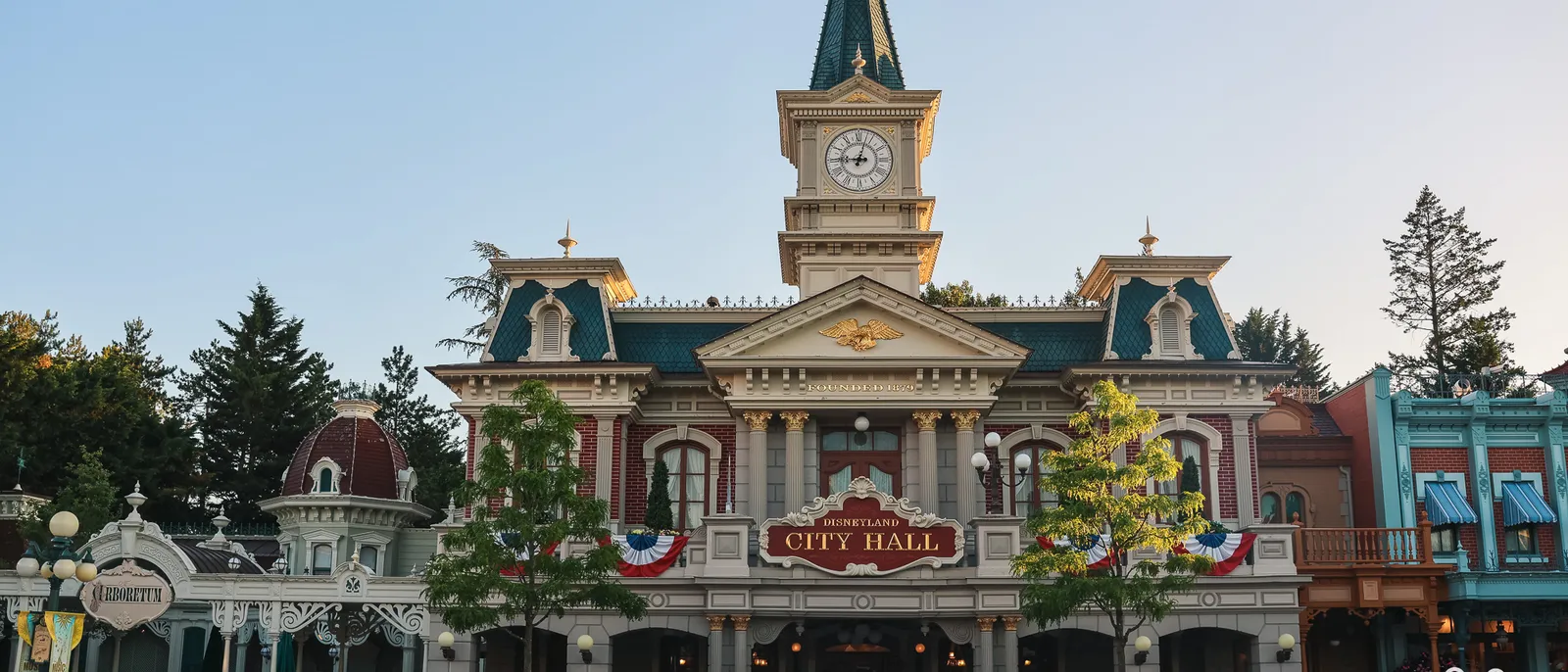 Façade de City Hall et sa tour horloge au lever du soleil, Main Street déserte au Parc Disneyland.