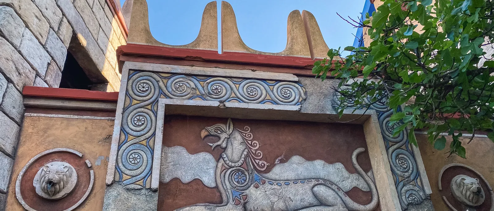 Fresque antique d’un fauve et de spirales sous des cornes stylisées à Europa-Park