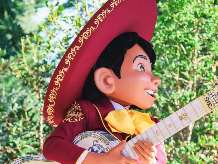 Close-up profile of Miguel, with a burgundy sombrero and white guitar, during Miguel’s Fiesta Latina at Disneyland Paris