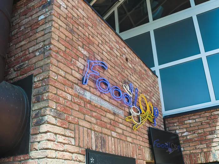Enseigne néon du restaurant Food Loop sur un mur de briques, à Europa-Park