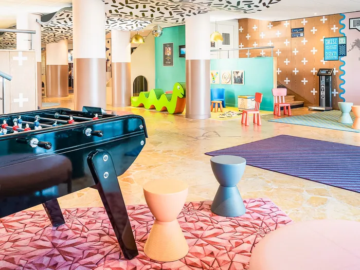 Espace de jeux coloré avec baby-foot, tabourets et coin enfants à l'Adagio Aparthotel Val d'Europe