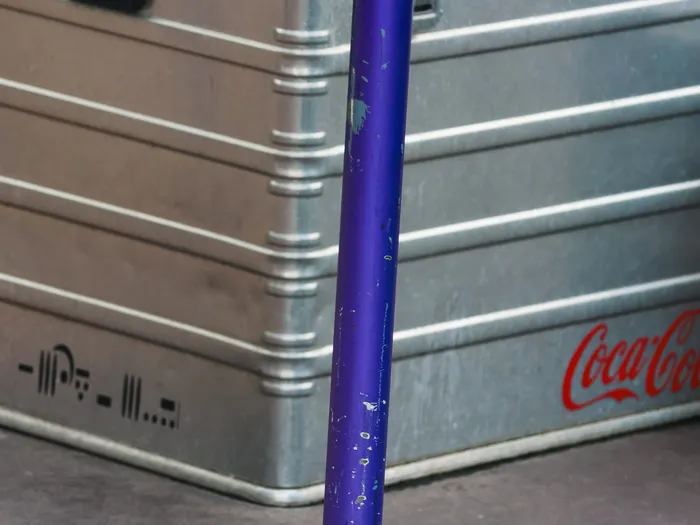 Gros plan sur une caisse en aluminium ornée du logo Coca-Cola devant le kiosque Cool Station, Discoveryland.