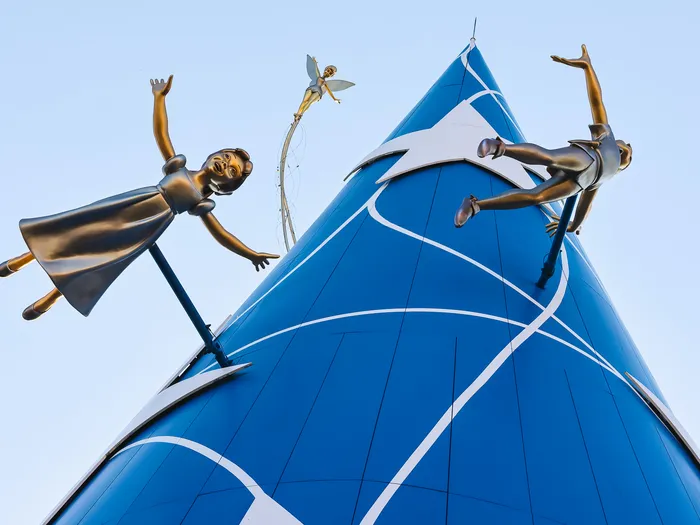 Statues en bronze de personnages volant autour d’un sommet conique bleu