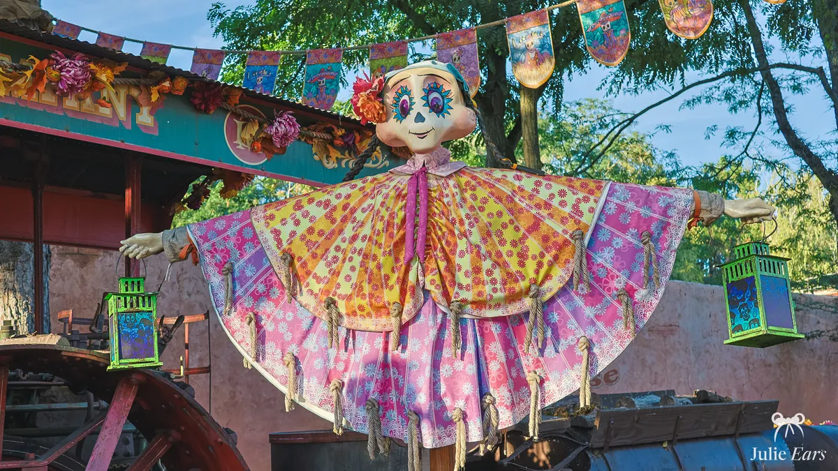 Frontierland Halloween decoration: a figure with skull face make-up, in a colourful floral dress, surrounded by garlands, at Disneyland Paris