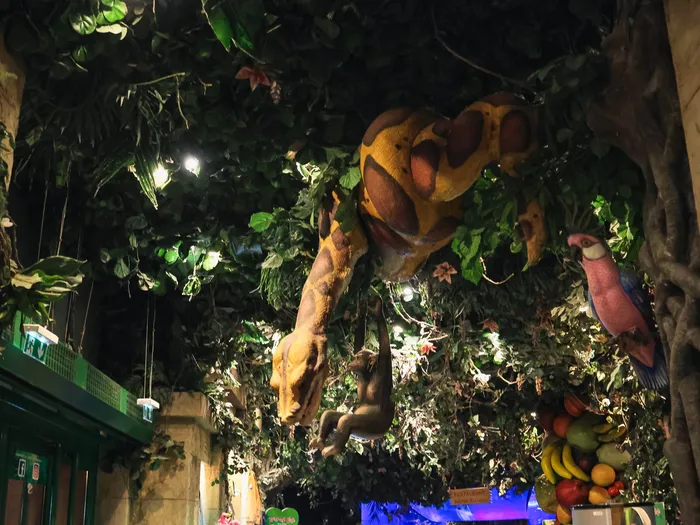Animatronic snake and pink parrot on the ceiling, in the foliage of the Boutique Rainforest Café