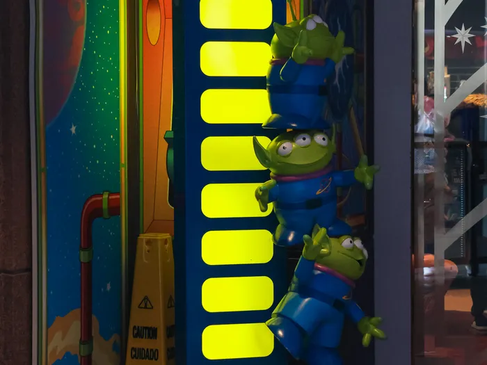 Green Toy Story alien figures stacked on an illuminated column, at Disneyland Paris