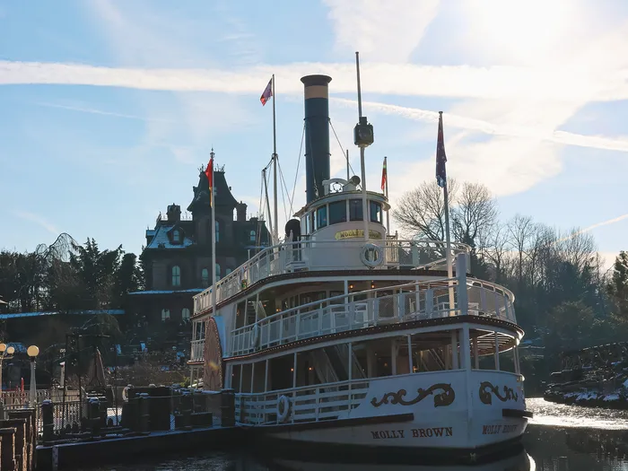 Le vapeur Molly Brown amarré au Thunder Mesa Riverboat Landing, avec le manoir Phantom Manor derrière, ciel d’hiver ensoleillé