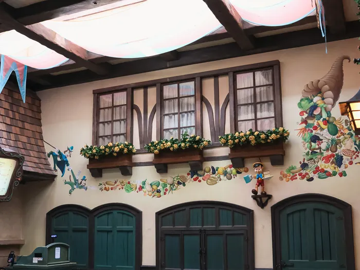 Fresque murale du restaurant Au Chalet de la Marionnette à Fantasyland, fenêtres à colombages et corne d’abondance