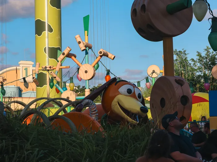 Figure du chien à ressort Zigzag au milieu des décors colorés de Toy Story, au coucher du soleil.