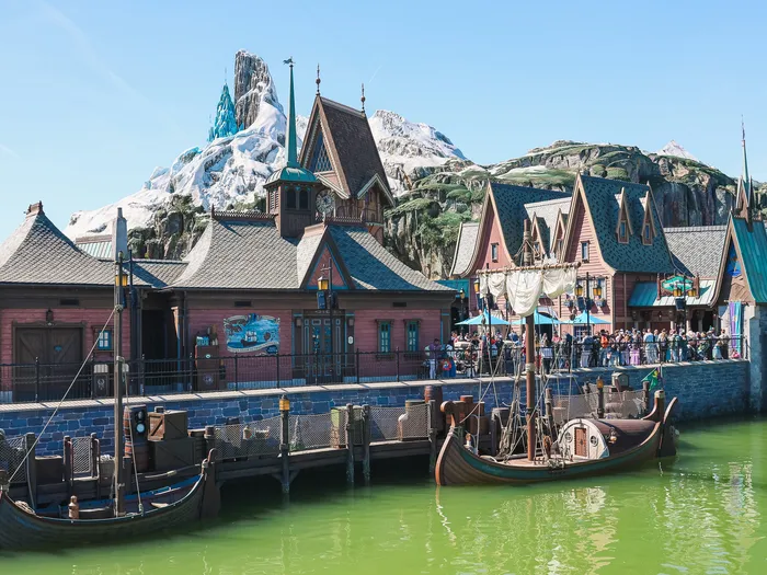 Maisons du port d’Arendelle, drakkars amarrés et montagne enneigée en fond, dans World of Frozen.