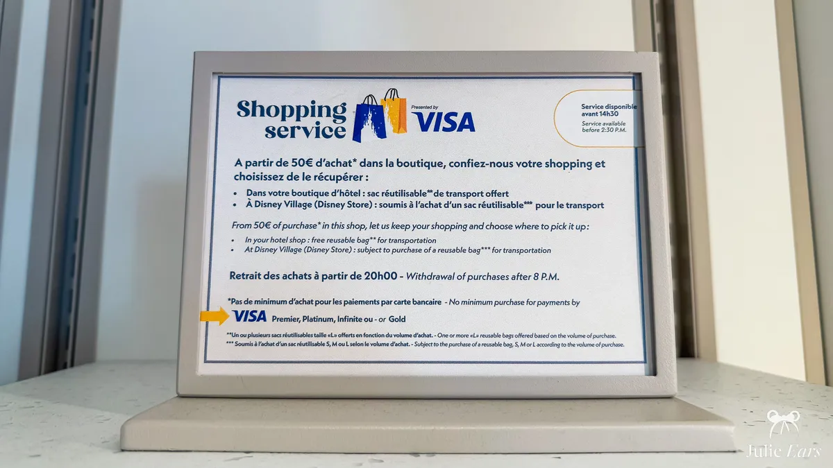 Panneau du Shopping Service dans une boutique de Disneyland Paris, indiquant qu’à partir de 50€ d’achat on peut faire garder ses achats et les récupérer à l’hôtel ou au Disney Village.