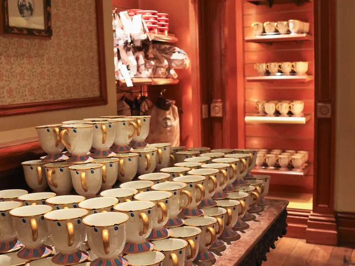 Tasses Zip de La Belle et la Bête empilées sur une table, boutique Disney & Co. sur Main Street U.S.A. à Disneyland Paris
