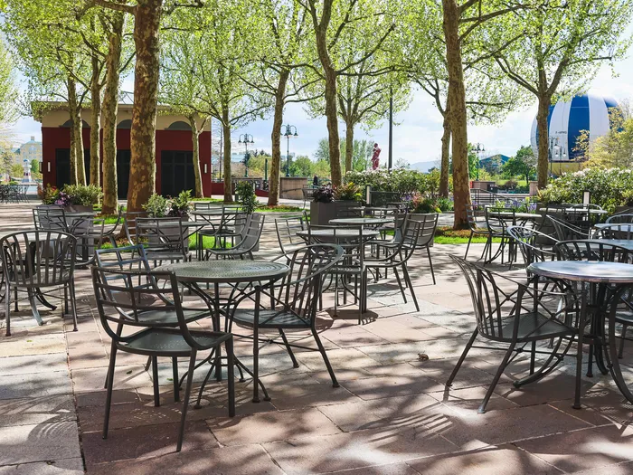 Terrasse ombragée aux tables en fer forgé sous les platanes, à l’hôtel New York The Art of Marvel