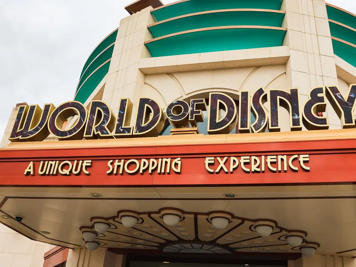 Art Deco facade at Disney Village, with a green dome and a gold "World of Disney" sign.
