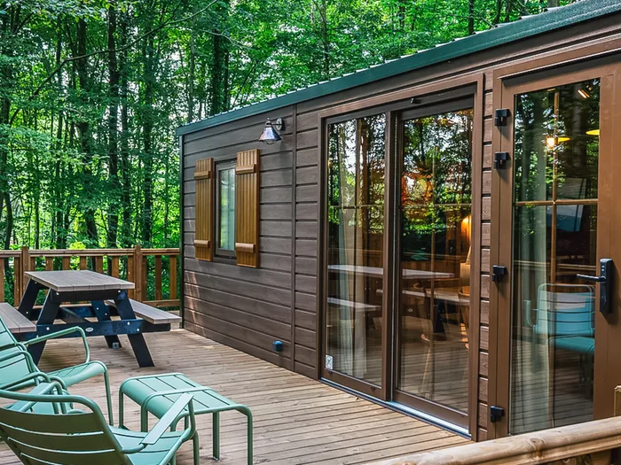 Terrasse en bois et transats d’un bungalow du Davy Crockett Ranch entouré de forêt