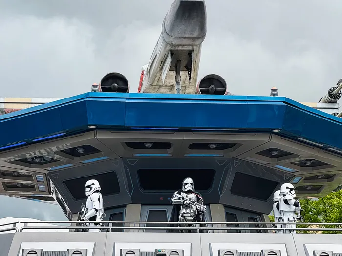 Trois stormtroopers montent la garde sous un X-wing, sur la scène Star Wars de Discoveryland.