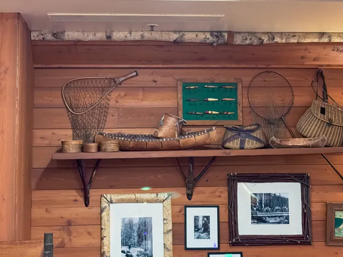 Étagère en bois du Hunter’s Grill garnie d’une épuisette, d’un canoë miniature et de paniers d’osier