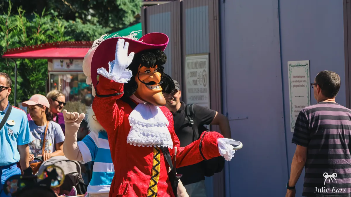 Captain Hook, in a red coat and large feathered hat, greeting visitors during a meet and greet at Disneyland Paris.