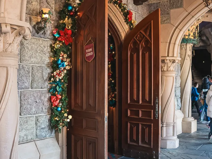 Entrée de La Boutique du Château à Disneyland Paris, sous les arcades du château, décorée pour les fêtes.