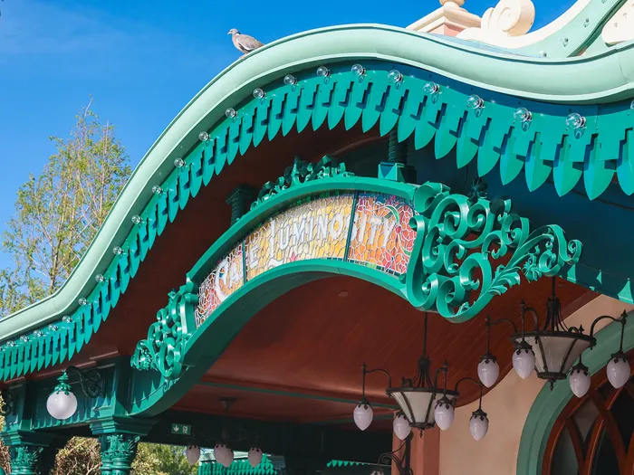 Green Art Nouveau canopy of Café Luminosity at Disneyland Paris, with its orange mosaic sign and bud-shaped lamps