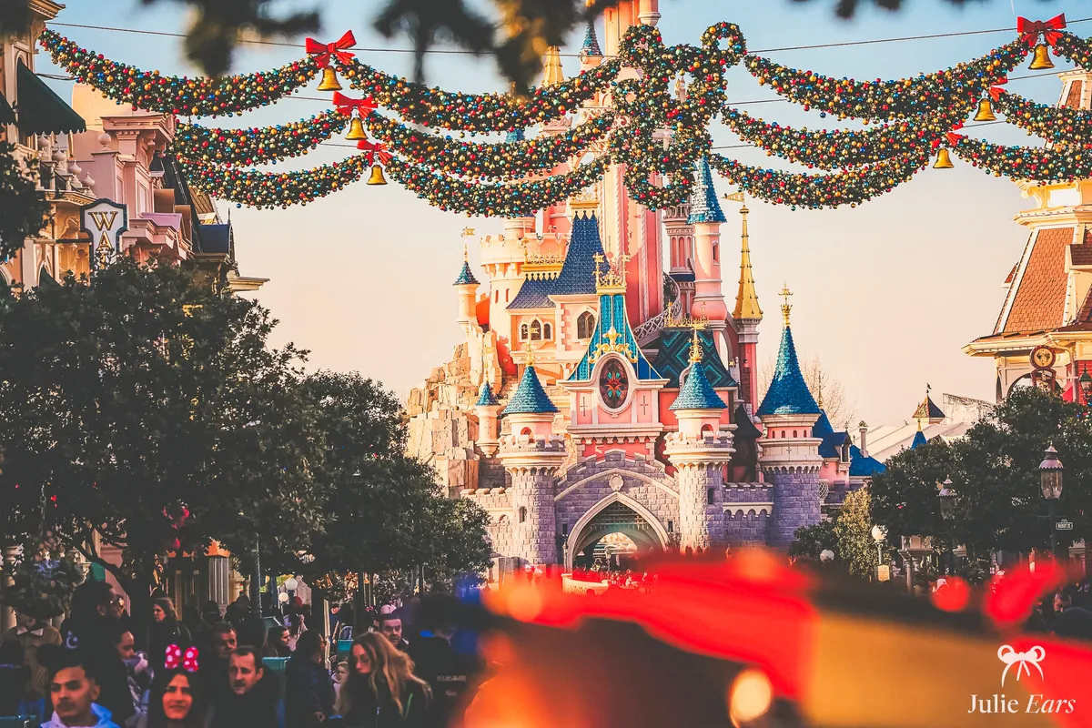 Main Street décorée pour Noël avec ses guirlandes et le château de la Belle au Bois Dormant à Disneyland Paris