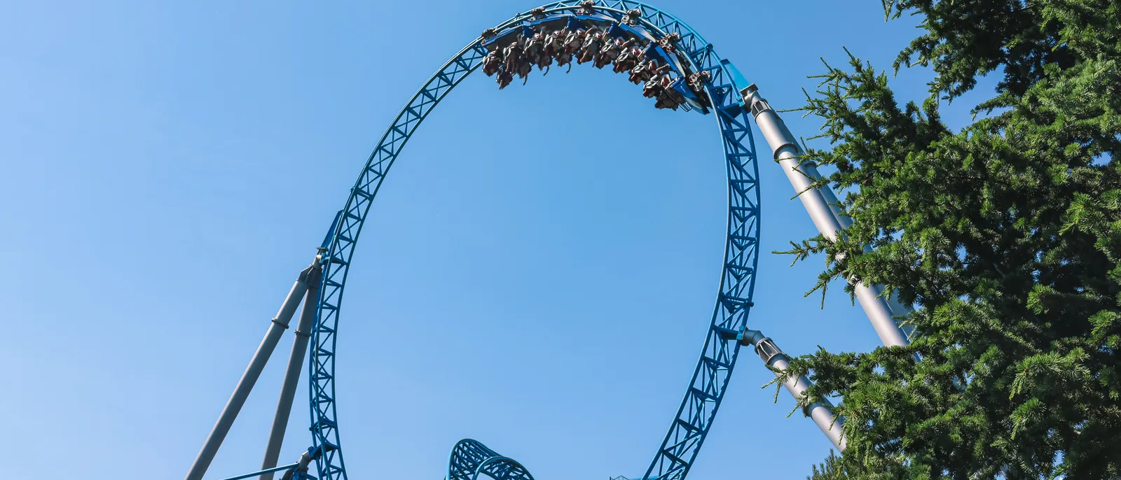 Train bleu franchissant un grand looping vertical contre le ciel bleu à Europa-Park