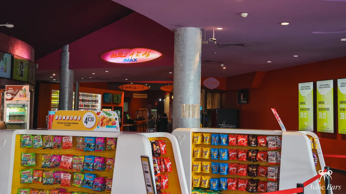 Foyer of the Disney Village cinema with its illuminated IMAX sign, silver columns and confectionery stands full of bags of sweets