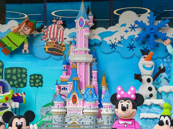 LEGO display case with a pink Disney castle, Peter Pan, Buzz Lightyear, Elsa and Minnie.