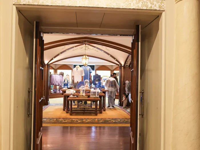 Porte d’entrée en bois de la Royal Collection Boutique surmontée de son enseigne bordeaux et dorée.