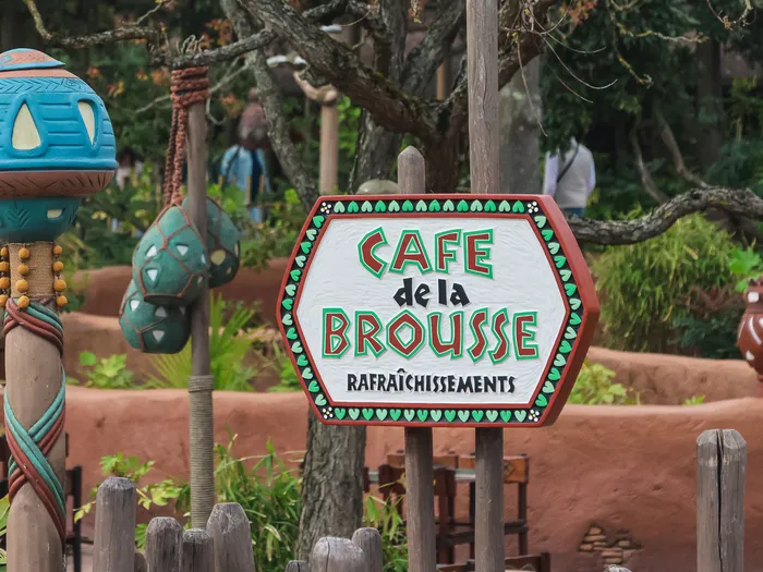 Enseigne sculptée du Café de la Brousse et décor africain du restaurant à Adventureland