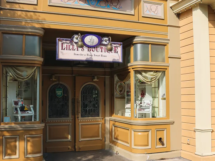 Yellow Victorian-style facade and entrance of Lilly’s Boutique at Disneyland Paris, with its "Items for a Home Sweet Home" sign.