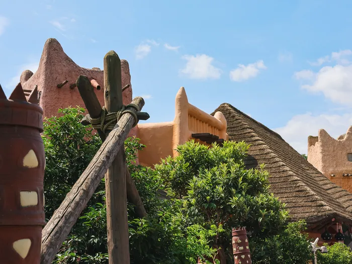 Toits en terre cuite et chaume du restaurant Hakuna Matata vus du jardin, poterie décorée au premier plan