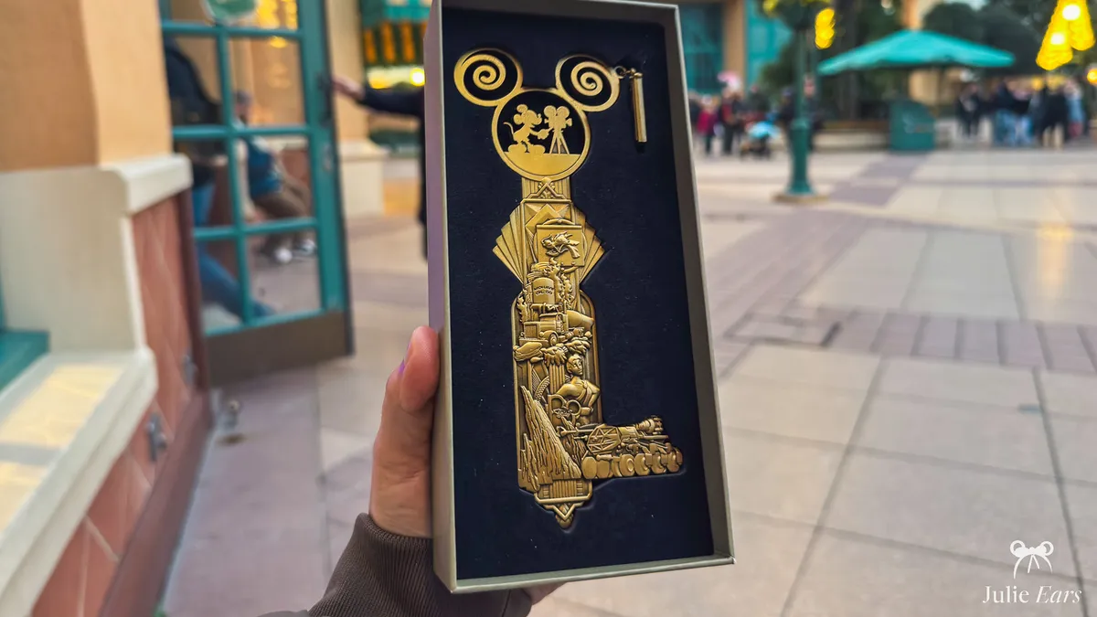 Gold collector’s key topped with Mickey and a film camera, with cinema scenes in relief, in its black case at Disneyland Paris