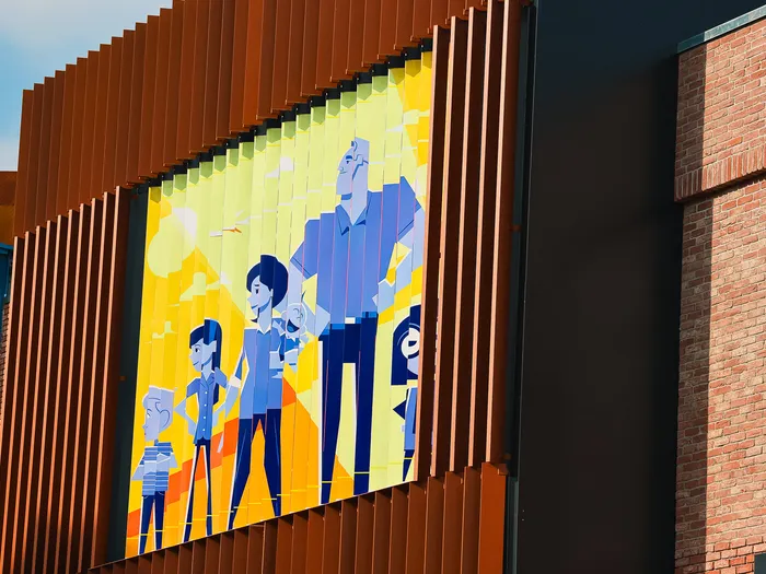 Panneau illustré des Indestructibles en tons bleus sur la façade de Disney Style, au Disney Village