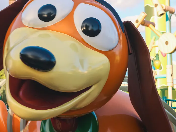 Gros plan sur le visage souriant de la figurine Slinky le chien à l’avant de l’attraction Slinky Dog Zigzag Spin