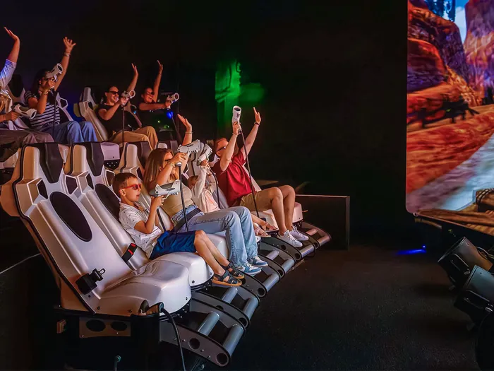 Enfants avec lunettes 3D dans les fauteuils du cinéma 4D de l’Explorers Hotel devant l’écran
