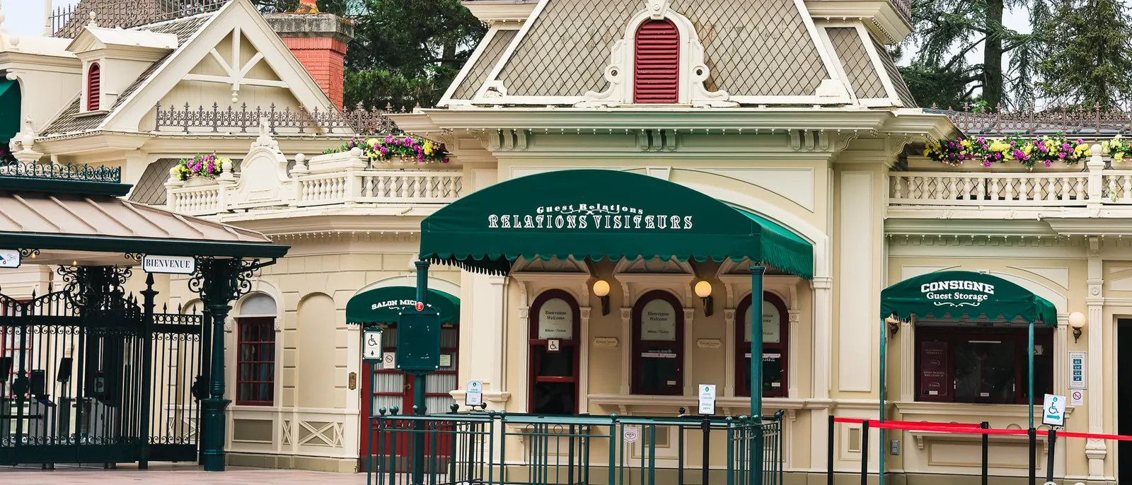 Bâtiment aux auvents verts des Relations Visiteurs et de la Consigne, près de l’entrée de Disneyland Paris.